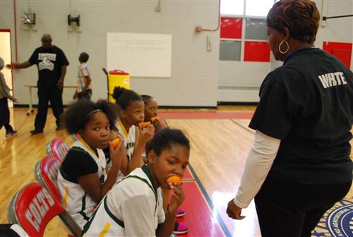 Coach White giving the girls oranges for half time snack during basketball game Coach White giving the girls oranges for half time snack during basketball game